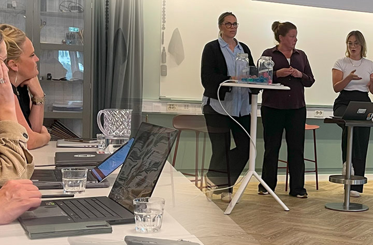 Tre på en scen som talar inför grupp