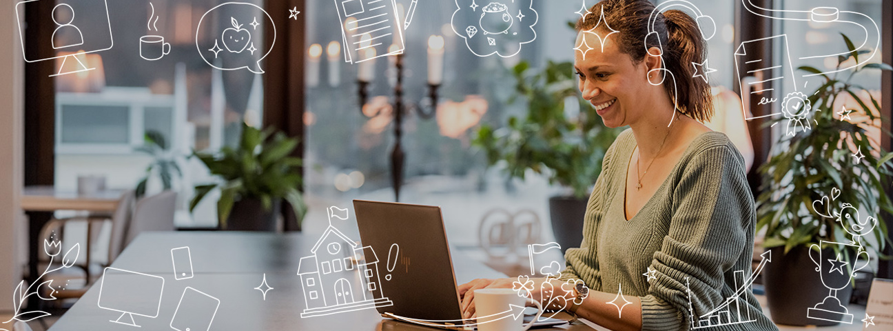 Glad Maria sitter med dator i en lounge