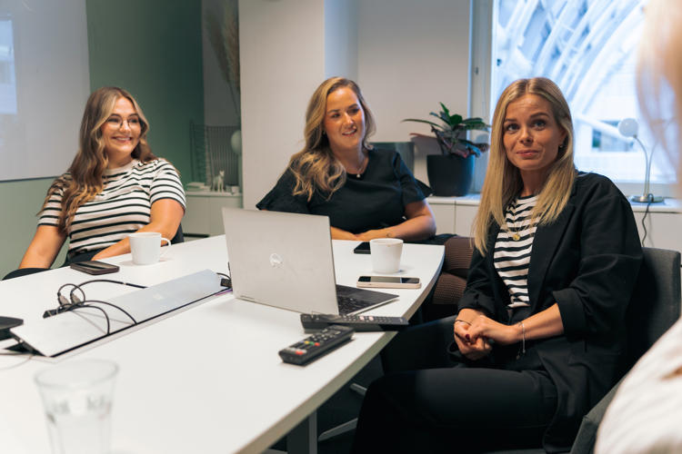 Glada tjejer runt ett konferensbord