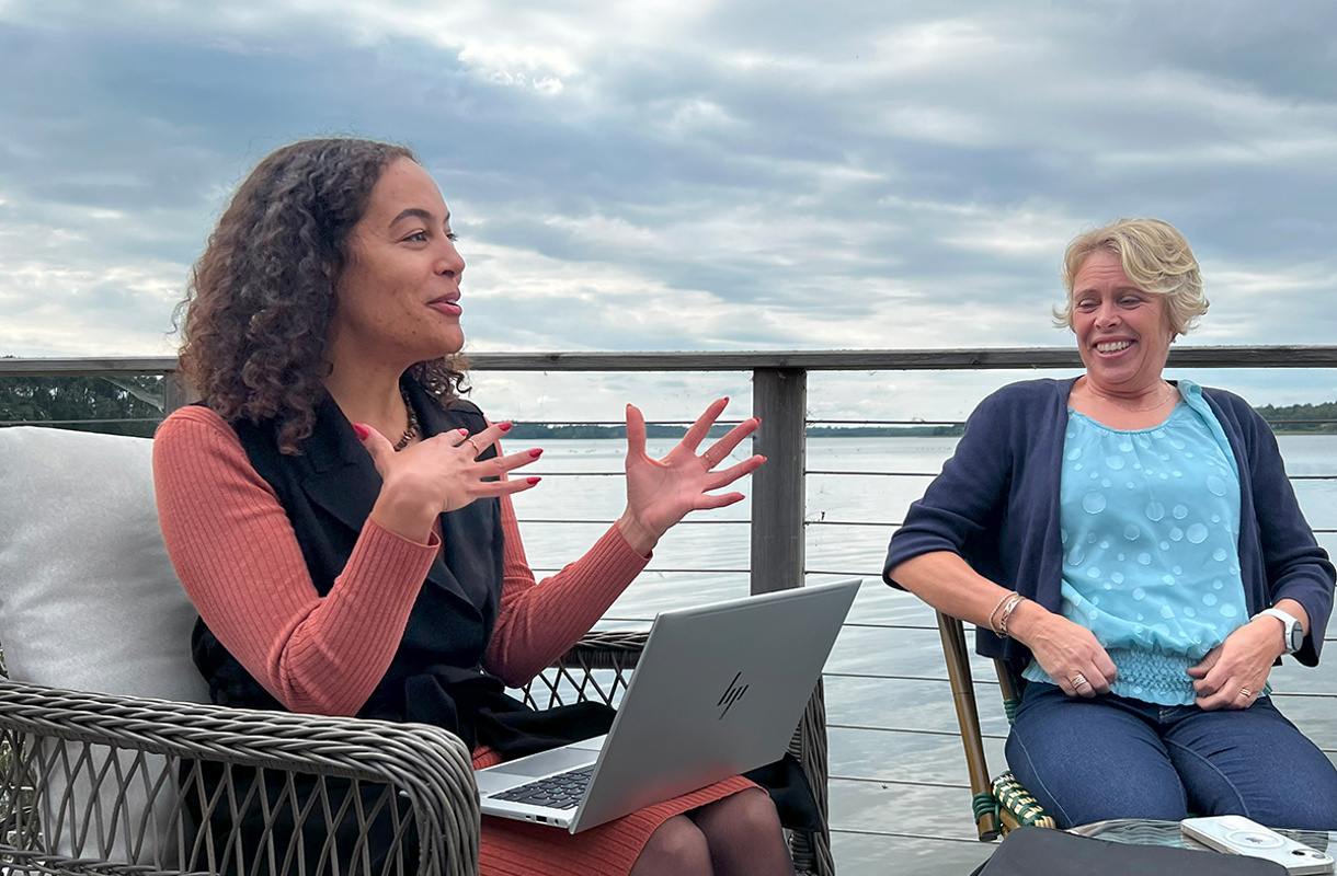 Två tjejer i utemiljö i diskussion framför dator