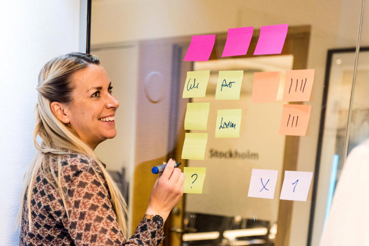 Tjej skriver post-it-lappar i workshop