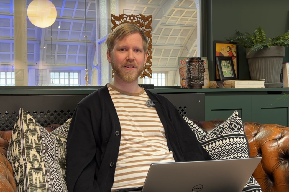 Medarbetare på Lexicon Interactive sitter i en soffa med en laptop i knät