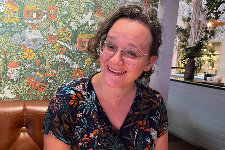 Marie på Lexicon Interactive framför blommig tapet