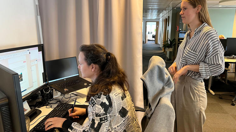 Kollega övervakar arbete vid dator