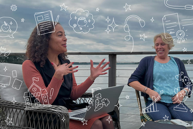 två tjejer med vatten bakom sig i diskussion vid dator