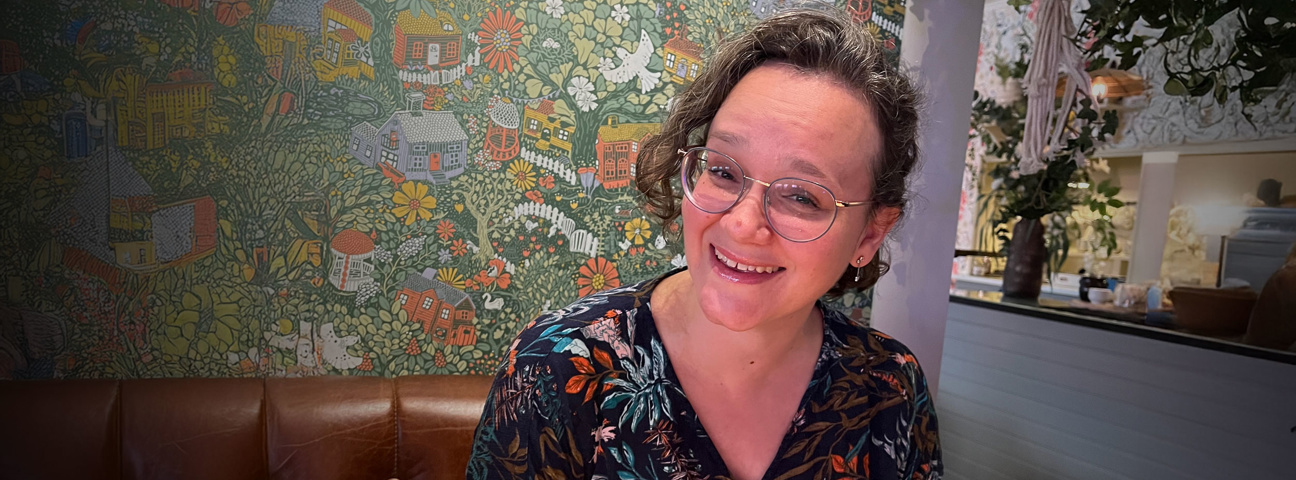 Marie på Lexicon Interactive framför blommig tapet