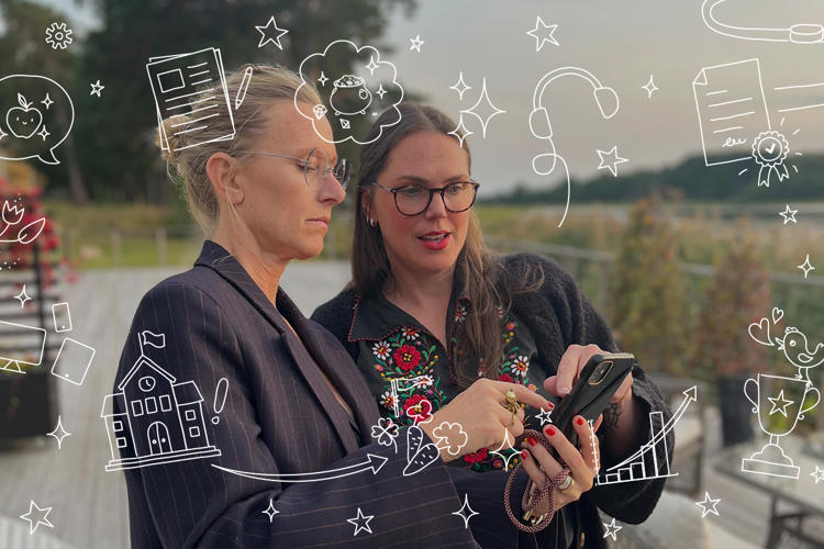 Två tjejer utomhus tittar i en mobil