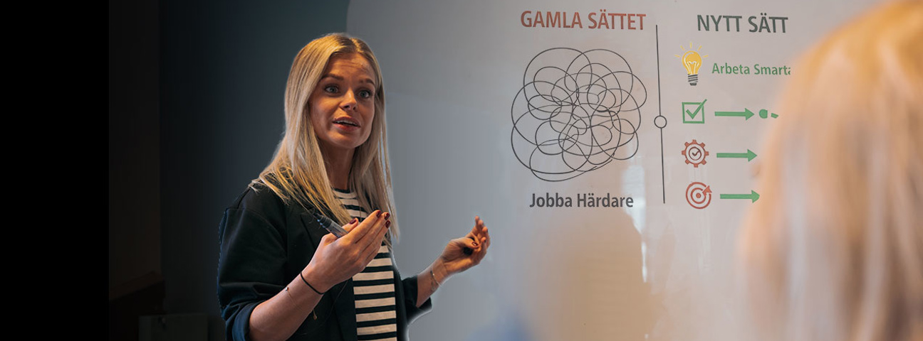 Kvinna visar på whiteboard skiiss med gamla och nya arbetssätt