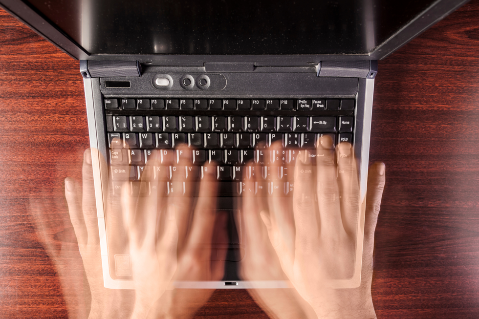 Händer rör sig snabbt över tangentbord