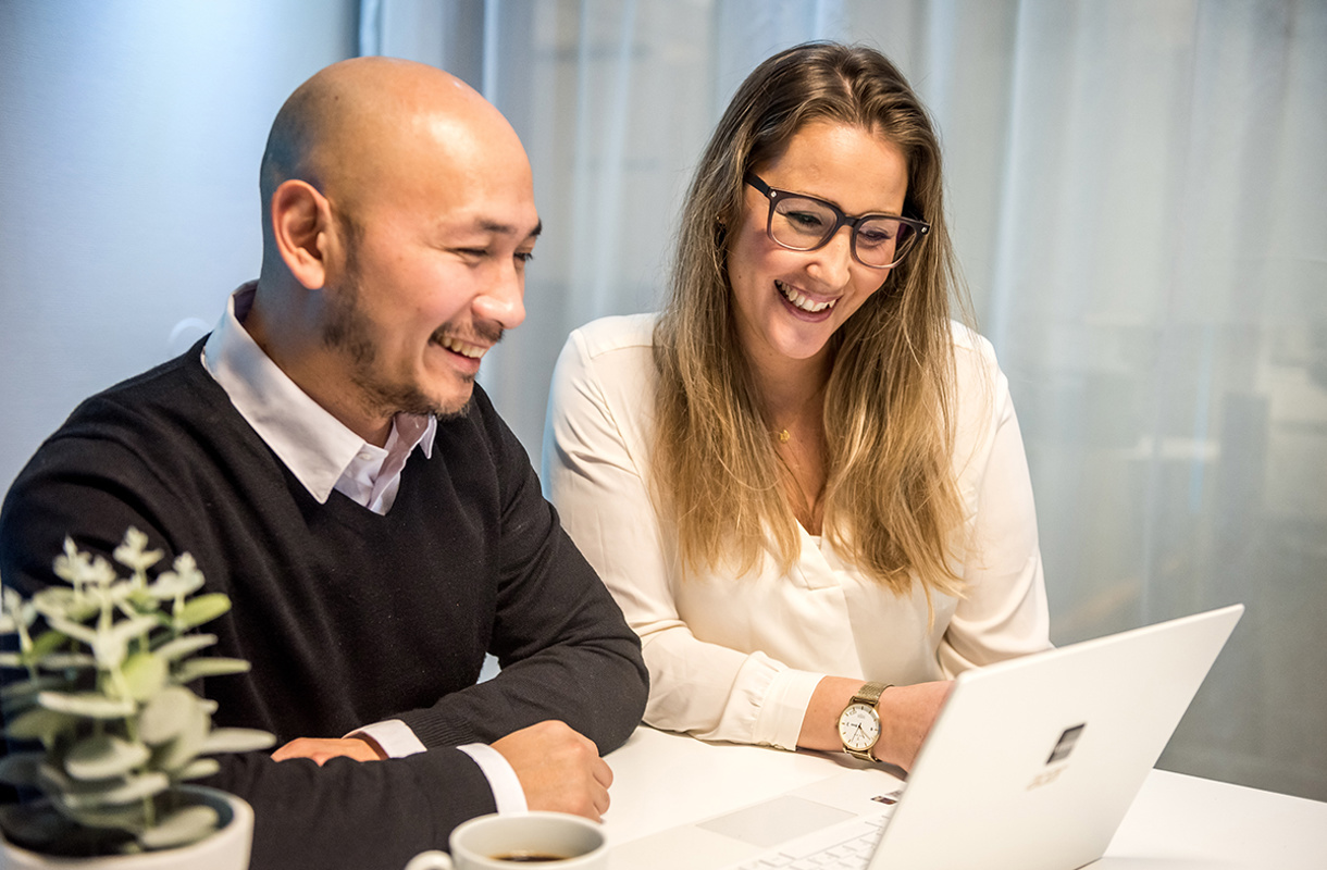 Två medarbetare framför en dator