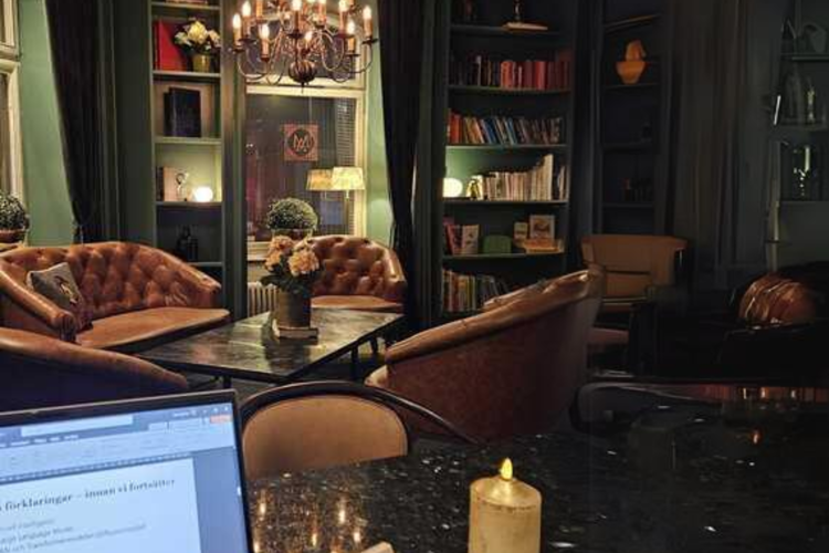 Hotell-lounge och laptop syns i hörnet